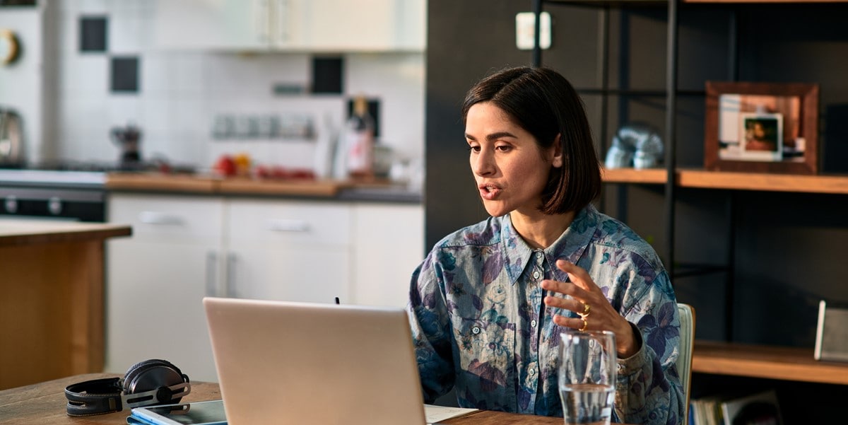 woman working at a desk talking during virtual meeting